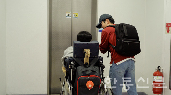 강의실로 이동하기 위해 엘레베이터 앞에 있는 김현욱 학우와 학습 도우미 (사진 촬영: 조하민 PD)